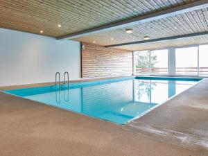 a swimming pool in a building with an indoor swimming pool at Studio Le Hameau D002 by Interhome in Les Collons