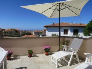 a patio with two chairs and an umbrella at Apartment Mansarda by Interhome in Rosignano Solvay +25 photos