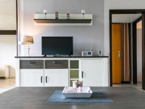 a living room with a flat screen tv on a counter at Holiday Home Fedderwardersiel-4 by Interhome in Fedderwarderdeich +23 photos