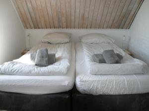 SchoondijkeにあるHoliday Home Helmrich by Interhomeのベッド2台が隣同士に設置された部屋です。