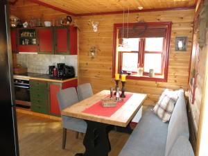 una cucina con tavolo e sedie in una cabina di Holiday Home Troll - TEM027 by Interhome ad Åmli
