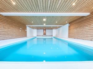 a swimming pool with blue water in a building at Studio Hameau D3 by Interhome in Les Collons