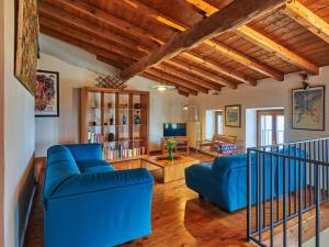 a living room with blue couches and a tv at Holiday Home Casa Stella-4 by Interhome in Spiazzi Di Caprino