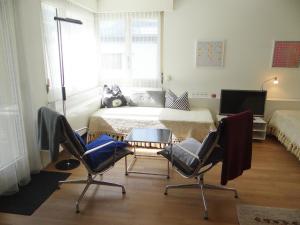- une chambre avec un lit, deux chaises et une table dans l'établissement Apartment Sunnmatt Süd Wohnung 245 by Interhome, à Engelberg