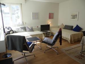 a room with two beds and a desk and a tv at Apartment Sunnmatt Süd Wohnung 245 by Interhome in Engelberg