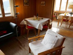 uma sala de jantar com uma mesa com uma toalha de mesa branca em Chalet Chalet Pitschun by Interhome em Grindelwald