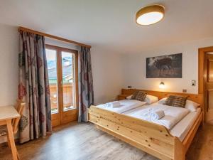 a bedroom with a large bed and a window at Holiday Home Haus Weickl by Interhome in Kaprun