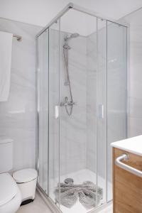 La salle de bains est pourvue d'une douche avec une porte en verre. dans l'établissement THE CLUB - Accommodation - Dining - Events, à San Miguel de Abona
