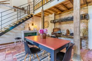 een eetkamer met een tafel en stoelen en een trap bij La grange in Trensacq