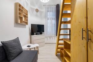 sala de estar con escalera, sofá y TV en Swarz's Downtown Apartment, en Budapest