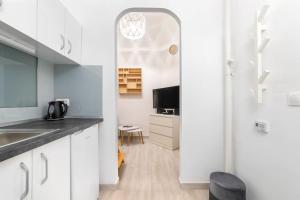 Una cocina con gabinetes blancos y un fregadero. en Swarz's Downtown Apartment, en Budapest