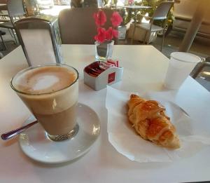 - une tasse de café et une viennoiserie sur une table dans l'établissement B&B Erifrà Piccolo Hotel, à Cosenza