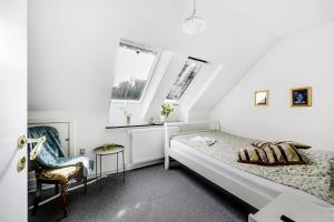 EngesvangにあるEngesvang Bed & Breakfast and Holiday Homeの白いベッドルーム(ベッド1台、椅子付)