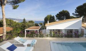 a villa with a swimming pool and a house at BelleVue in Cala Vinyes