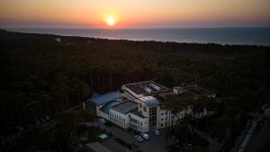 an aerial view of a building with the sunset in the background at Marena Wellness & Spa in Międzywodzie
