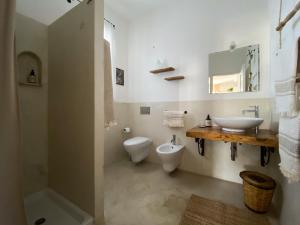 a white bathroom with a sink and a toilet at Sikalindi Apulian Farm&Living in Gagliano del Capo
