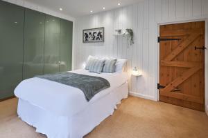 een slaapkamer met een wit bed en een schuifdeur bij Host & Stay - The Lodge in Warkworth