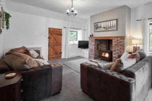 ein Wohnzimmer mit 2 Sofas und einem Kamin in der Unterkunft Host & Stay - The Lodge in Warkworth