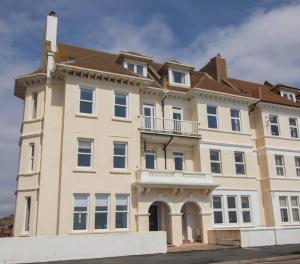 un gran edificio con un balcón en la parte superior. en The Courtyard, 30 Seconds to Sea By Air Premier, en Seaford