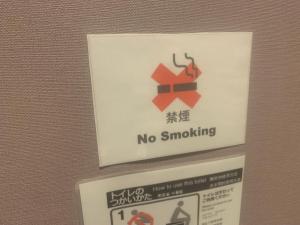 Un cartello che dice che non si fuma su un muro di Lodging Tokyo Ueno a Tokyo