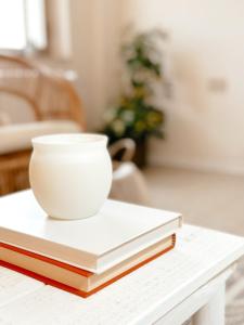 un tazón blanco sentado encima de dos libros en una mesa en Tabbihome Apartments - Costa dei Trabocchi, en Paglieta