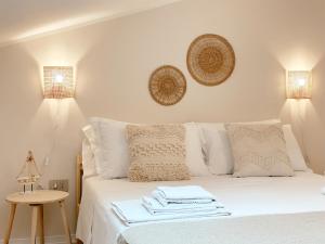Una cama blanca con dos toallas encima. en Tabbihome Apartments - Costa dei Trabocchi, en Paglieta