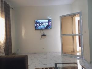 a living room with a television on a wall at Mamou hlm grang yoff in Dakar