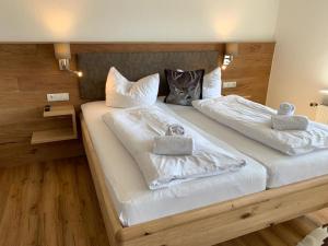 - une chambre avec 2 lits dotés de draps et d'oreillers blancs dans l'établissement Landhaus Sonne, à Hergensweiler