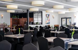 a dining room with tables and chairs and lights at Fala by Marena Wellness & Spa in Międzywodzie