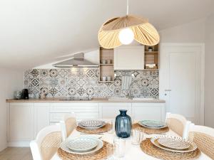 una cocina con una mesa con sillas y un jarrón en Tabbihome Apartments - Costa dei Trabocchi, en Paglieta 74 fotos más