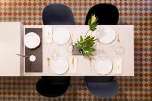 two black chairs with white plates on a table at 206 Via Roma in Linguaglossa +72 photos