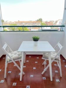 サンルーカル・デ・バラメダにあるApartamento GUADALQUIVIRの白いテーブルとバルコニー(椅子2脚付)