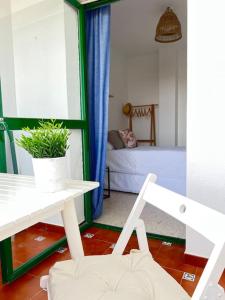 a living room with a white table and a chair at Apartamento GUADALQUIVIR in Sanlúcar de Barrameda