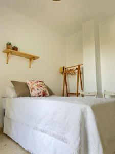 サンルーカル・デ・バラメダにあるApartamento GUADALQUIVIRのベッドルーム(白いベッド1台、木製の棚付)