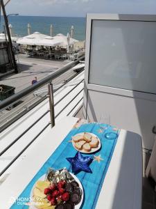 佩雷亞的住宿－Aktis Sea View Studios，阳台上的餐桌上放着一盘食物