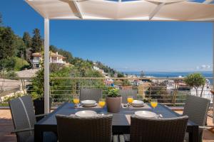 Una mesa y sillas en un balcón con vista al mar. en Orizontas Loft with Panoramic View, en Zakynthos