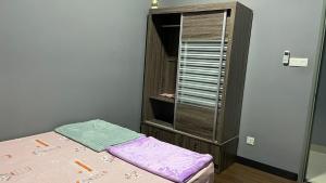 ein kleines Schlafzimmer mit einem Bett und einem Holzschrank in der Unterkunft Sandakan Homestay IJM Condo 3R2B Serenity Lodge 明悦之居 - 7 Pax in Bandar Indah