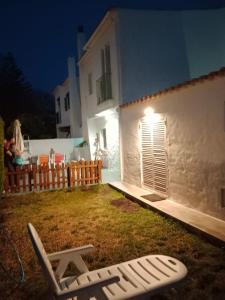un patio trasero por la noche con una silla de césped y un edificio en Casa Alma, en Campano