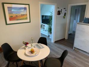 Zimmer mit einem Tisch und Stühlen sowie einer Küche in der Unterkunft Ferienwohnung  Am Sternbusch in Hau