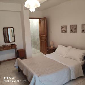 a bedroom with a bed and a mirror and a bathroom at Colors Apartments Pilio in Afissos