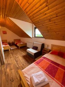 a attic room with two beds and a couch at House Leonarda in Grabovac