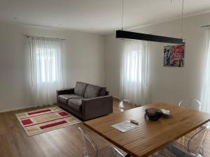 a living room with a table and a couch at G83Home-Appartamento moderno in zona Fiera in Vicenza