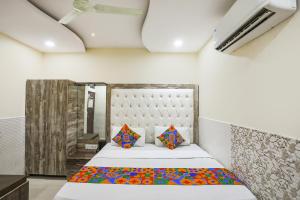a bedroom with a bed and two pillows at FabHotel Welcome in Kānpur