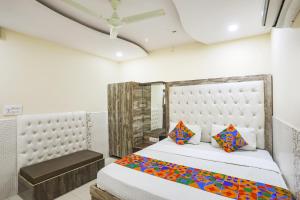 een slaapkamer met een groot bed en een stoel bij FabHotel Welcome in Kānpur