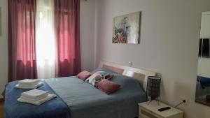 um quarto com uma cama azul com almofadas em Apartments & Room Danijel em Pinezici