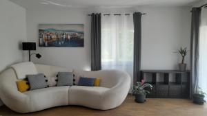 a living room with a white couch with pillows on it at Apartments & Room Danijel in Pinezici