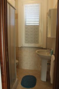 a bathroom with a sink and a toilet and a window at Villa Wight in Olmedo