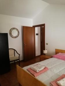 une chambre avec un lit, une chaise et un miroir dans l'établissement APP Angela - Ardaro 2, à Riva del Garda