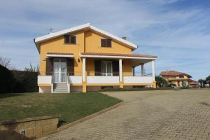 una casa amarilla con una entrada delante de ella en Villa Wight, en Olmedo