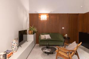 a living room with a green chair and a television at 206 Via Roma in Linguaglossa